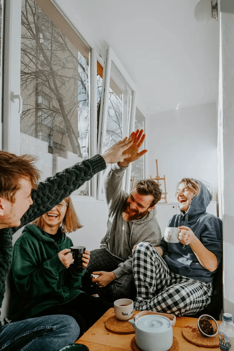 Group of friends laughing together at a sunset picnic in Lisbon